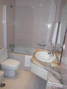 a bathroom with a sink and a toilet and a tub at Hotel Alameda in Albergaria-a-Velha