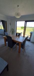 a dining room with a table and chairs and a chandelier at Barn Farm Guest House in Cold Norton