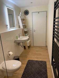 ein Bad mit einem WC und einem Waschbecken in der Unterkunft Moderne Ferienwohnung mit Retro-Charme in Wülfrath