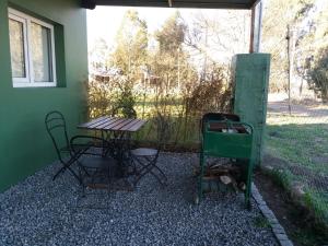 un patio con mesa y sillas junto a un edificio en Deptos del sur en Tandil