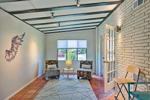 a living room with two chairs and a brick wall at Bright and Modern Texas Getaway - 7 Mi to The Alamo! in San Antonio