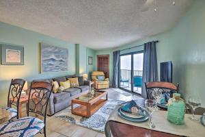 Ocean-View Condo with Balcony on Daytona Beach! في Daytona Beach Shores: غرفة معيشة مع أريكة وطاولة وكراسي