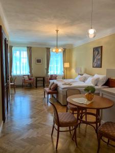 Habitación de hotel con cama, mesa y sillas en Penzion SECESE en Telč