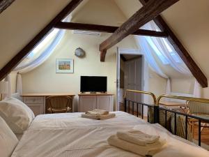 una camera da letto con un letto e due asciugamani di Penzion SECESE a Telč