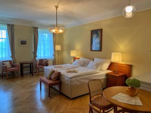 Habitación de hotel con cama, mesa y sillas en Penzion SECESE en Telč