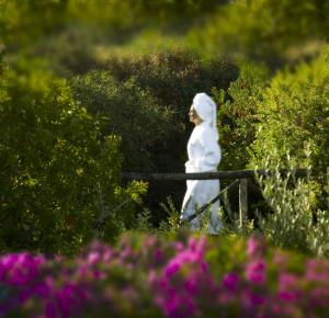 a statue of a woman walking through a garden with flowers at Hotel Caesar Augustus in Anacapri