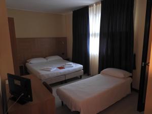 a hotel room with two beds and a window at Hotel Guidi in Mestre