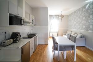 una cucina con tavolo e tavolo e sedie bianchi di Spa Apartments Theresia a Dubí