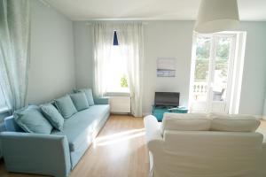 un soggiorno con divano bianco e blu di Spa Apartments Theresia a Dubí