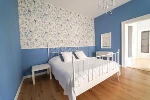 ein blaues Schlafzimmer mit einem weißen Bett und blauen Wänden in der Unterkunft Spa Apartments Theresia in Dubí