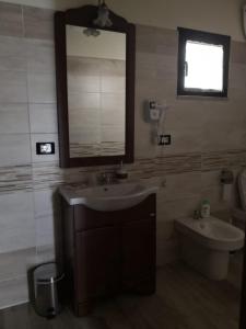 La salle de bains est pourvue d'un lavabo, d'un miroir et de toilettes. dans l'établissement Camera matrimoniale 1 per vacanza al mare VILLA FRANCA, à Cariati