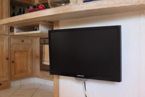 una TV a schermo piatto appesa a un muro in cucina di Villetta Privata a Porto Cervo a Porto Cervo