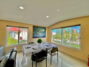 una sala da pranzo con tavolo, sedie e finestre di Apartamento cálido y moderno en la entrada de la zona hotelera a Cancún