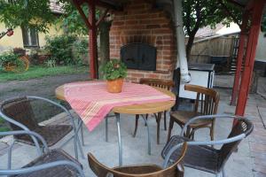 a table and chairs with a plant on a patio at Piri Vendégház in Hajdúböszörmény