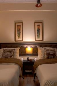 ein Schlafzimmer mit 2 Betten und einer Lampe auf einem Tisch in der Unterkunft The Mandarin Inn in Gilgit