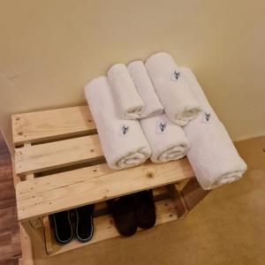 einen Haufen Handtücher und Schuhe auf einem Holzregal in der Unterkunft The Mandarin Inn in Gilgit