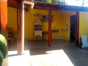 a room with a yellow wall with a chair in it at Casa de temporada Lindas Cachoeiras 10 in Paraty