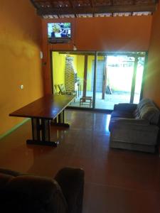 - un salon avec une table et un canapé dans l'établissement Casa de temporada Lindas Cachoeiras 10, à Parati