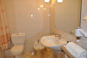 W łazience znajduje się toaleta, umywalka i lustro. w obiekcie Hotel "Zajazd Napoleoński" w Warszawie