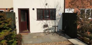 a small white house with a door and two chairs at Seashells Cottage in Lytham St Annes