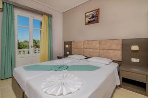 una camera da letto con un grande letto bianco con un ombrello bianco di Plaka Beach Resort a Vasilikós