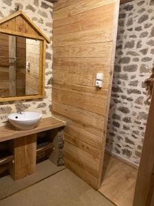 uma casa de banho com um lavatório e um espelho em La Forge em Allègre