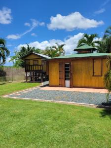 a house with a green roof and a grass yard at Ariami Rose in Aguada
