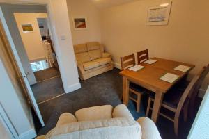 een woonkamer met een tafel en een bank bij Glen View a Stones Throw away from The Gower! in Swansea