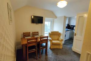 a living room with a table and a chair at Glen View a Stones Throw away from The Gower! in Swansea