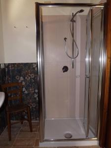 La salle de bains est pourvue d'une douche avec une porte en verre. dans l'établissement Piccolo Gesto d'Affetto, à Ripe