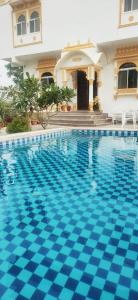 a swimming pool in front of a house at Royal Heritage Haveli Udaipur in Udaipur