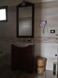 La salle de bains est pourvue d'un lavabo et d'un miroir. dans l'établissement Camera matrimoniale 2 per vacanza al mare- VILLA FRANCA, à Cariati