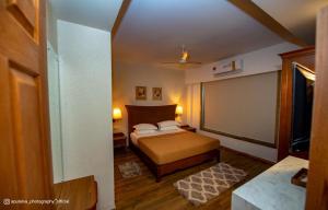 a small bedroom with a bed and a large window at SHARVARI BEACH HOME STAY at Mangalore by Vaishnavi Reveries in Mangalore +34 photos