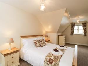 a bedroom with a large white bed and a window at 8 The Light in Malmesbury