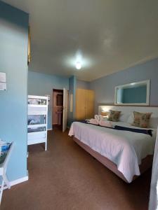 a bedroom with a bed and a bunk bed at Pili Pili Beach Cabanas in Sedgefield