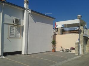 a white building with a gate and a house at Apartments and Rooms Jasna in Hvar