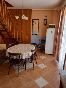 cocina con mesa, sillas y nevera en Holiday home in Balatonmariafürdo 19400, en Balatonmáriafürdő