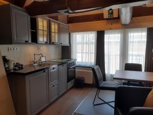 a kitchen with white cabinets and a table and chairs at VRYE HEERLYKHEYD ( adults only ) studio 3 in Middelburg