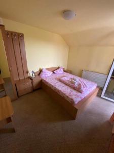 1 dormitorio con 1 cama con edredón rosa en Pensiunea Floare de Colt, en Deva