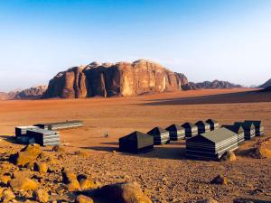 a group of buildings in the middle of a desert at Wadi Rum Cave Camp &Jeep Tour in Wadi Rum