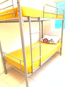 Etagenbett in einem Schlafsaal mit gelben Etagenbetten in der Unterkunft FEMALE ONLY-AnaRuby Backpackers- Metro Station Mashreq in Dubai
