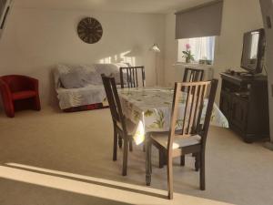 une salle à manger avec une table et des chaises ainsi qu'une chambre dans l'établissement Appartement 2 pièces équipé à Roppenheim Alsace, à Roppenheim