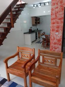 two wooden benches in a living room with a staircase at Casa Beija-Flor in Trindade