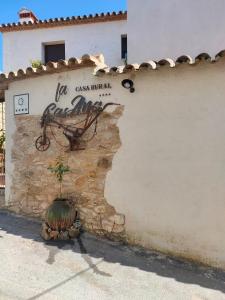 un muro con un cartello sul lato di un edificio di Casa Rural La CasAna a Fuente del Arco