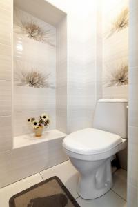 a bathroom with a toilet and flowers on the wall at Apartment 3, room 4, Tamanska, Дарії Гусяк in Lviv