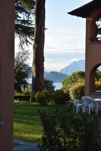 a view from the porch of a house with tables and chairs at Landscapesilvia 1 Aria in Menaggio