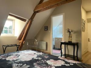 1 dormitorio con 1 cama grande con colcha de flores en Gîte Le Domaine d Orphée en Marmagne