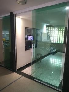 an open glass door with a stool inside of a building at Kitnet em Santos a melhor cidade do litoral paulista. in Santos