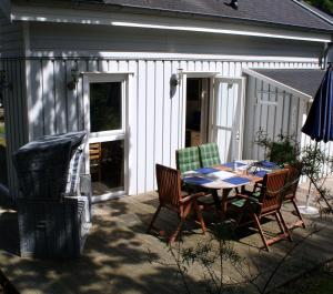 a patio with a table and chairs in front of a building at Ferienhaus-Kinderlieb in Baabe
