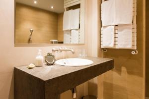 a bathroom with a sink and a mirror at Hotel Els Caçadors de Ribes in Ribes de Freser